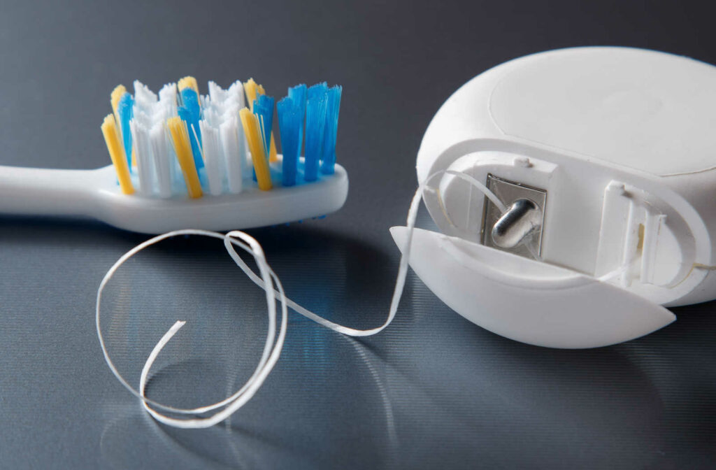 Close-up of toothbrush and dental floss. Proper brushing and flossing can help reduce your chance of developing cavities or tooth decay.